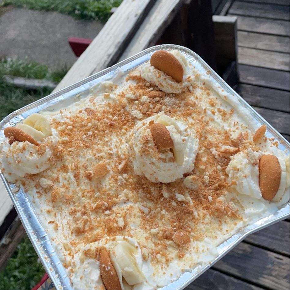 Banana pudding dessert with layers of banana, vanilla wafers, and whipped cream